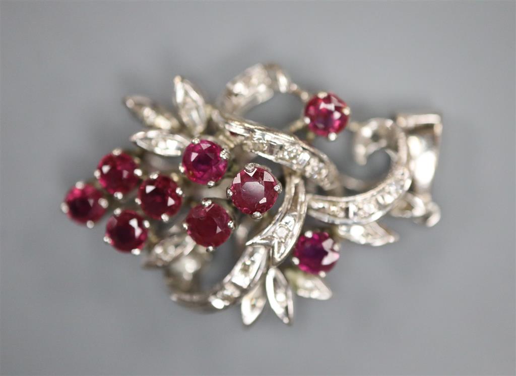 A modern 18k white metal, ruby and diamond chip set scroll pendant, 30mm, gross 5.6 grams.